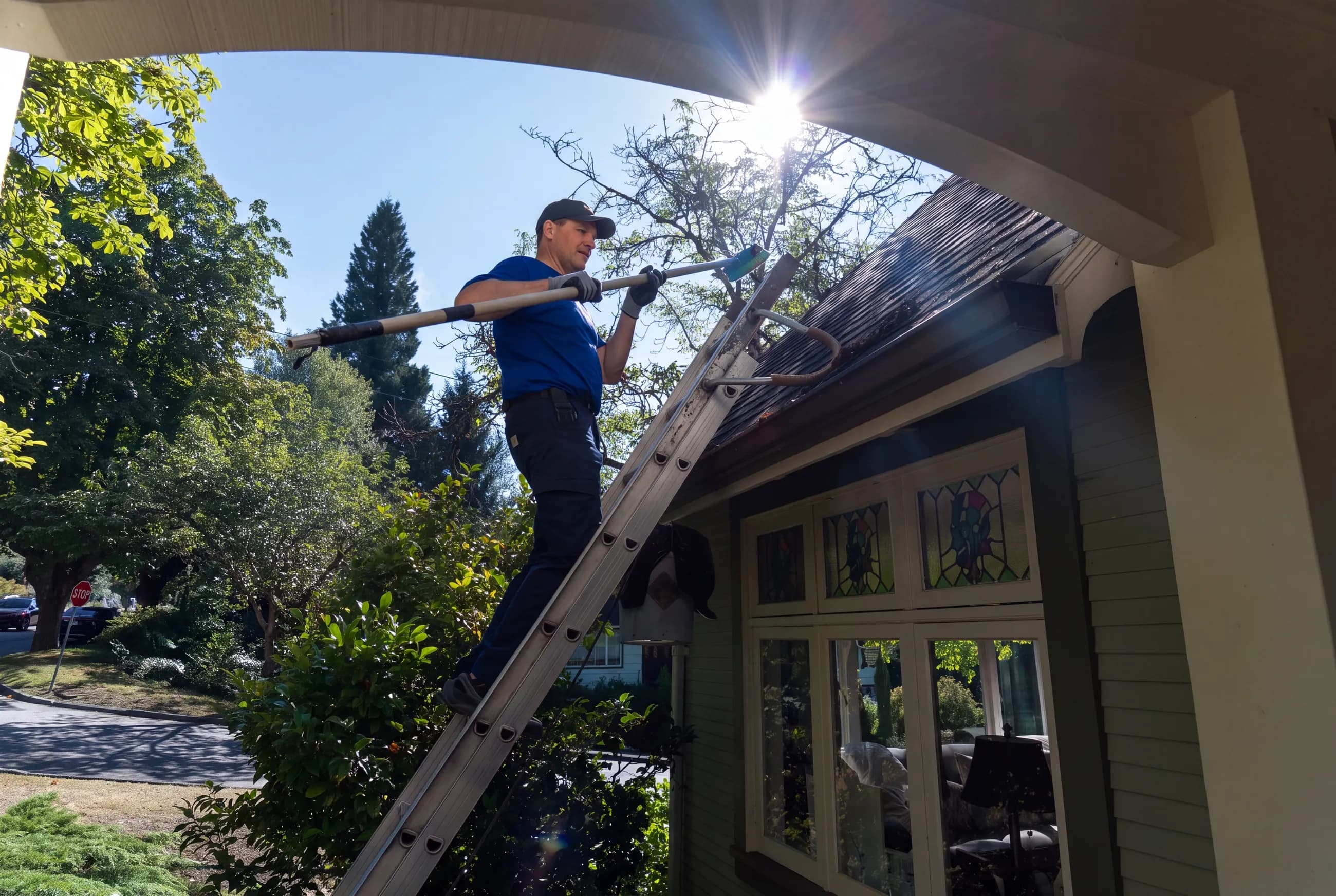 Holland Home Services crew cleaning a moss-covered roof in Greater Vancouver
