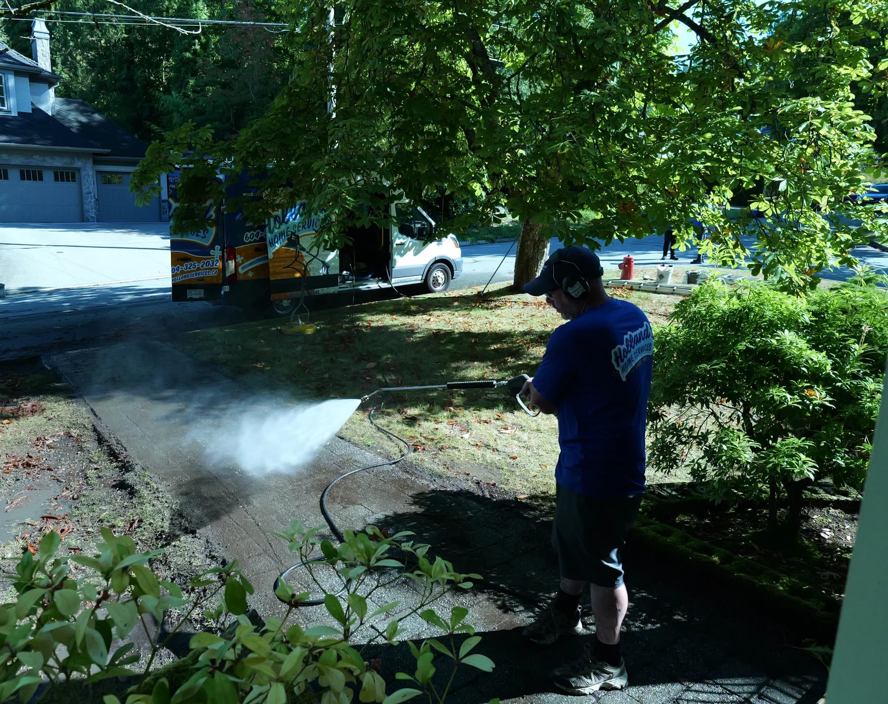 Holland Home Services crew pressure washing a driveway