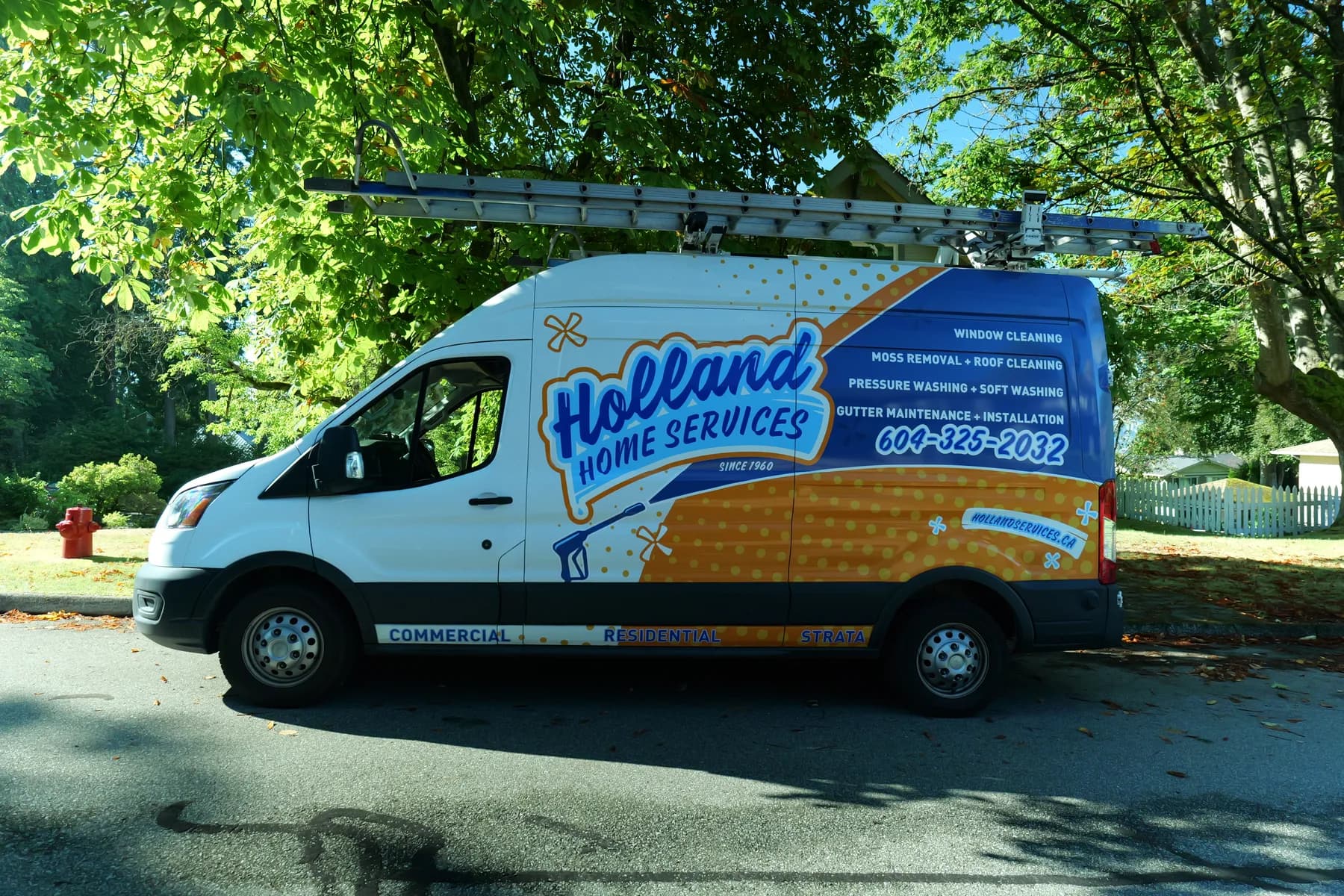 The Holland Home Services branded van parked on a leafy Vancouver street